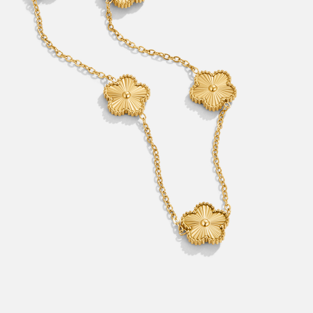 Golden Clover Cluster Necklace, flat-lay chain with gold flower motifs on white