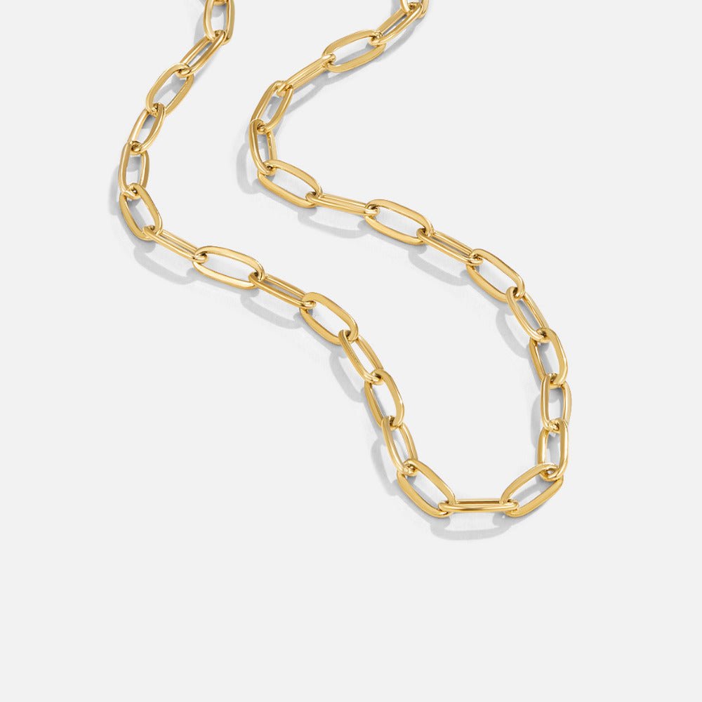 18K Gold Paperclip Charm Necklace, gold chain laid in a loose S-curve on a white background