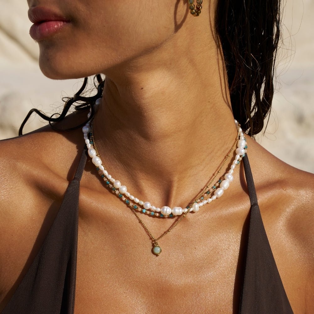 Alea Pearl Bead Necklace, worn on a model's neck with a pendant layered below