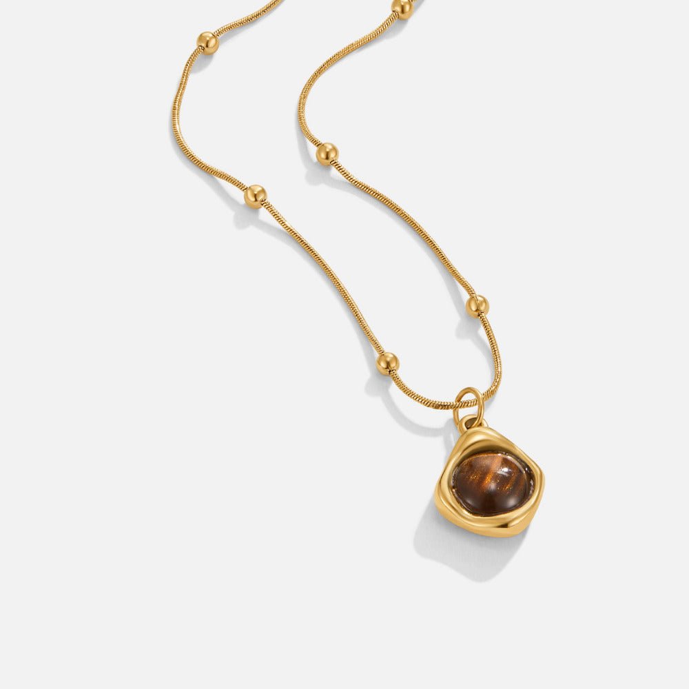 Amber Stone Pendant Necklace, gold chain with beaded links and a brown stone pendant on white