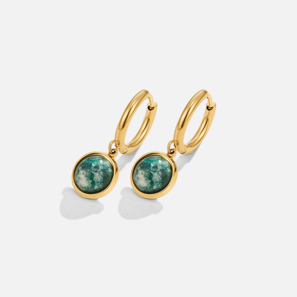Amelia Green Stone Hoop Earrings, a pair of gold hoops with green stone drops, on a plain