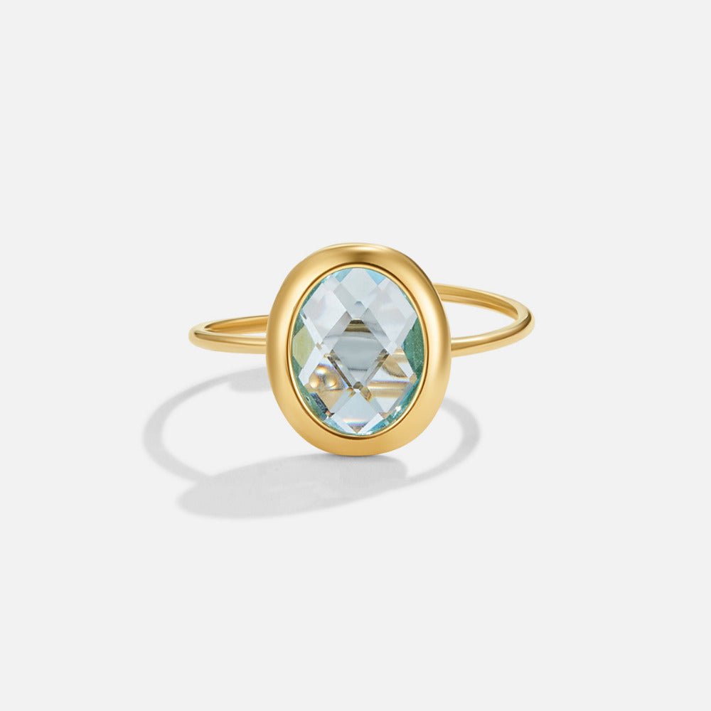 Aquamarine Crystal Gold Ring, standalone on white, oval pale blue faceted stone in gold bezel