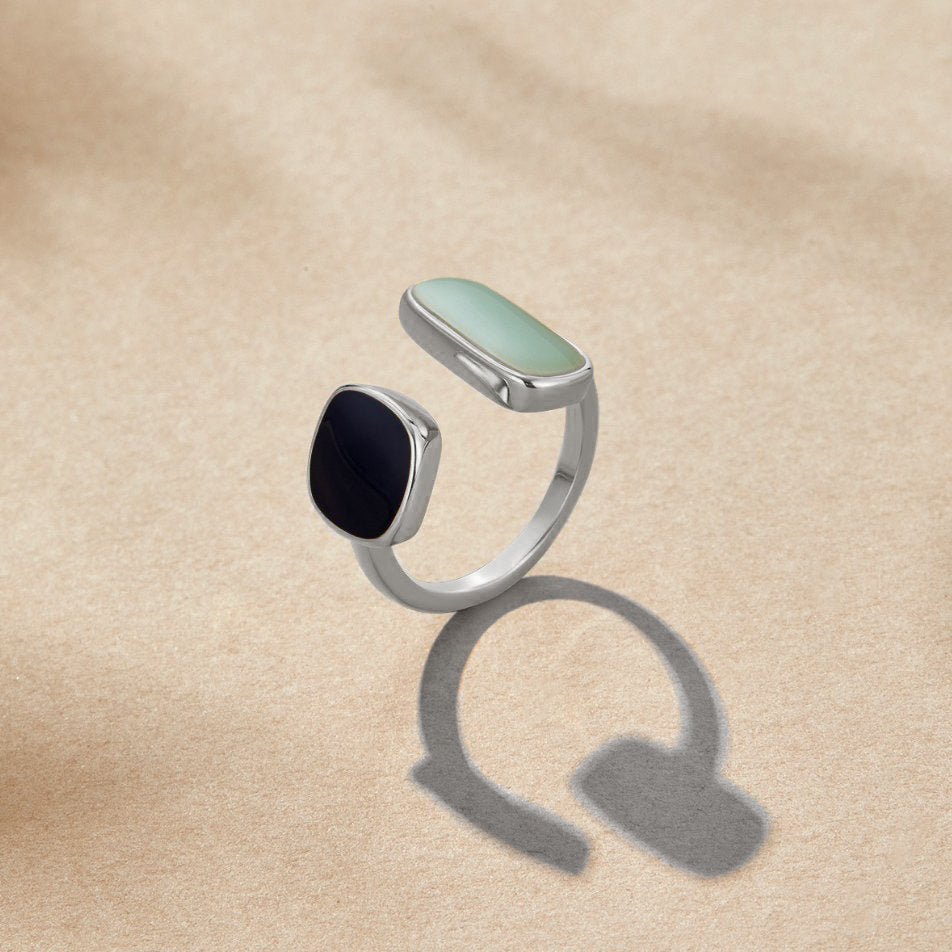 Aquamarine Wrap Silver Ring, standing upright on sand-coloured fabric, mint and black stones