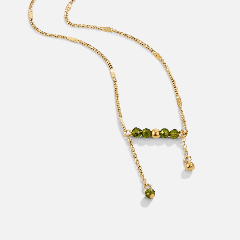 Arizona Green Bead Tassel Necklace, laid flat on white, gold chain with green faceted beads
