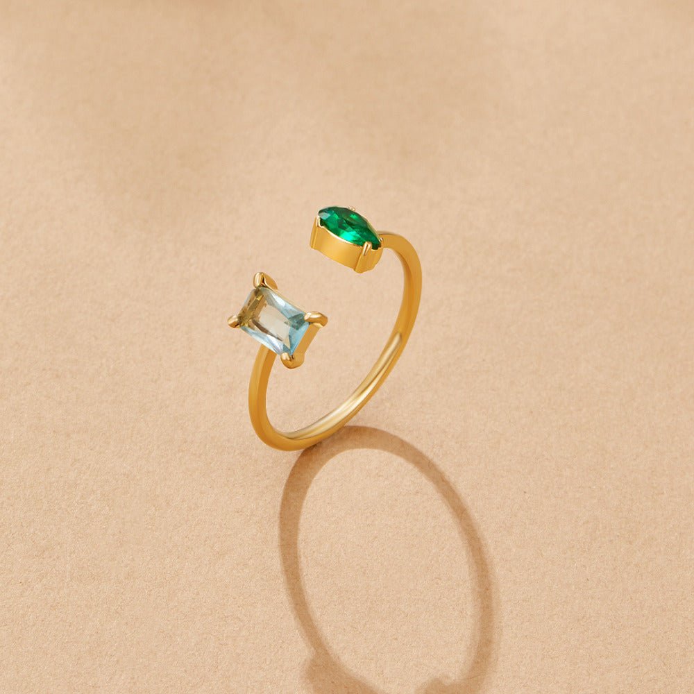 Aurora Aqua Green Crystal Ring, open gold ring on beige surface, aqua and green stones