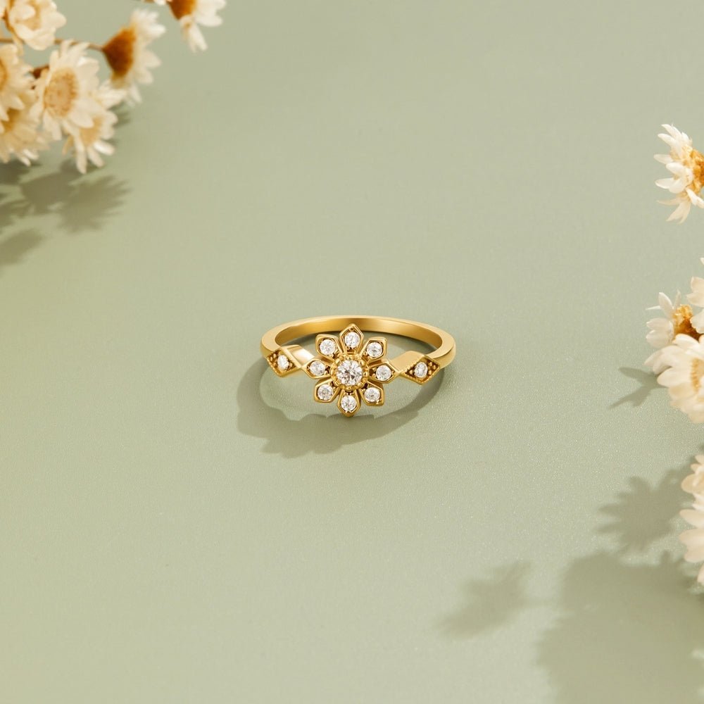 Aurora Crystal Flower Ring, gold ring lying flat on sage green, with dried flowers around