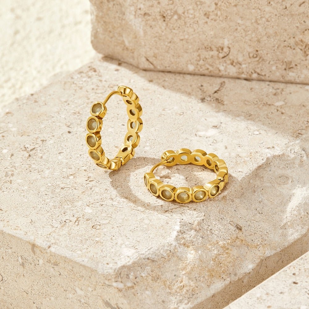 Beaded Arizona Hoop Earrings, a pair of hoop earrings on a stone surface, gold with pale green