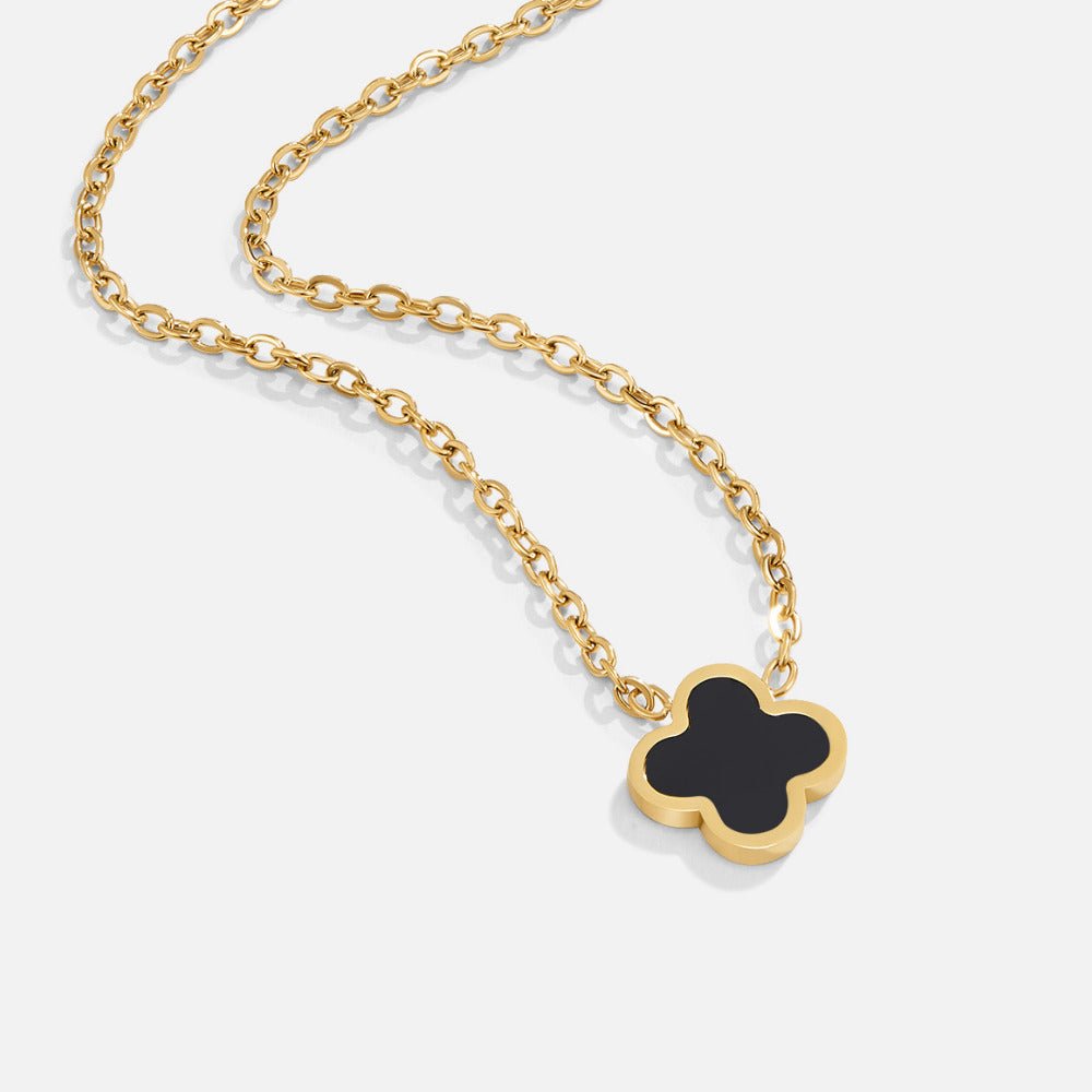 Black Clover Necklace, gold chain necklace laid flat with a black four-leaf clover pendant