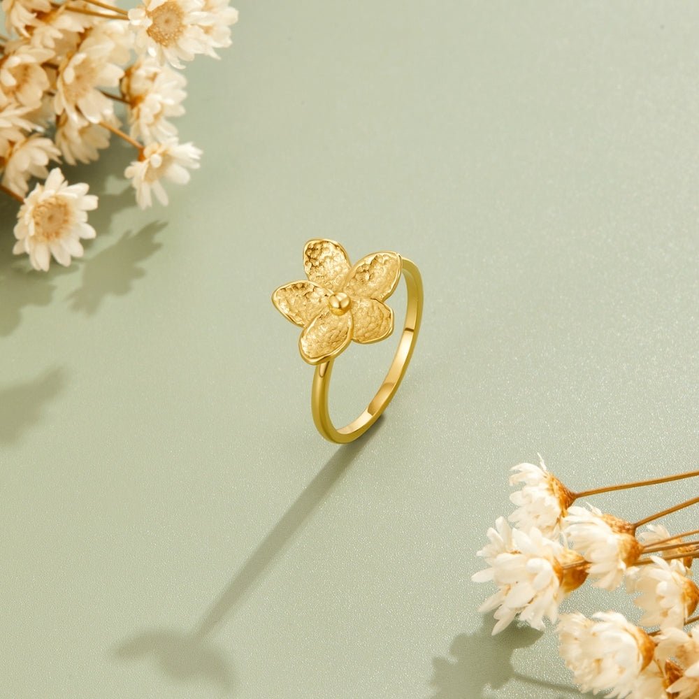 Blooming Gold Flower Ring, gold flower ring standing upright on pale green surface, dried