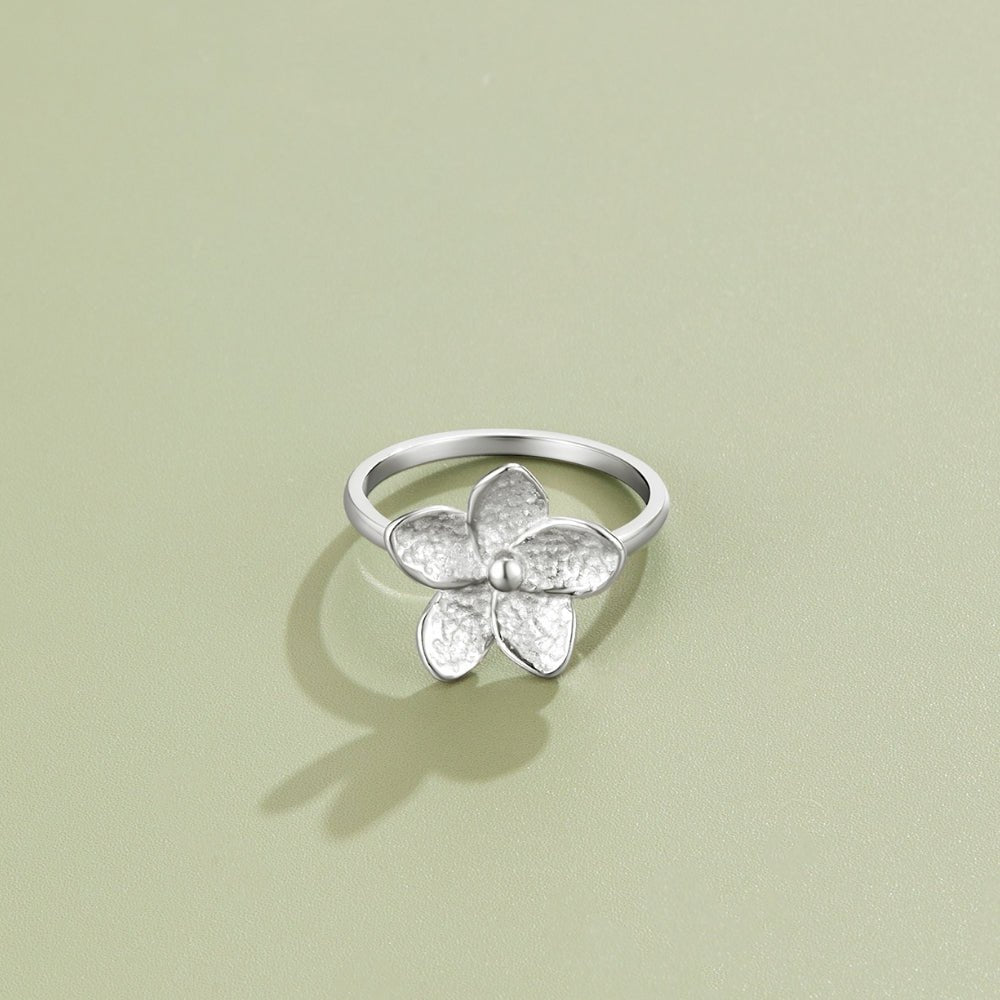 Blooming Silver Flower Ring, silver ring with five textured petals on sage green surface
