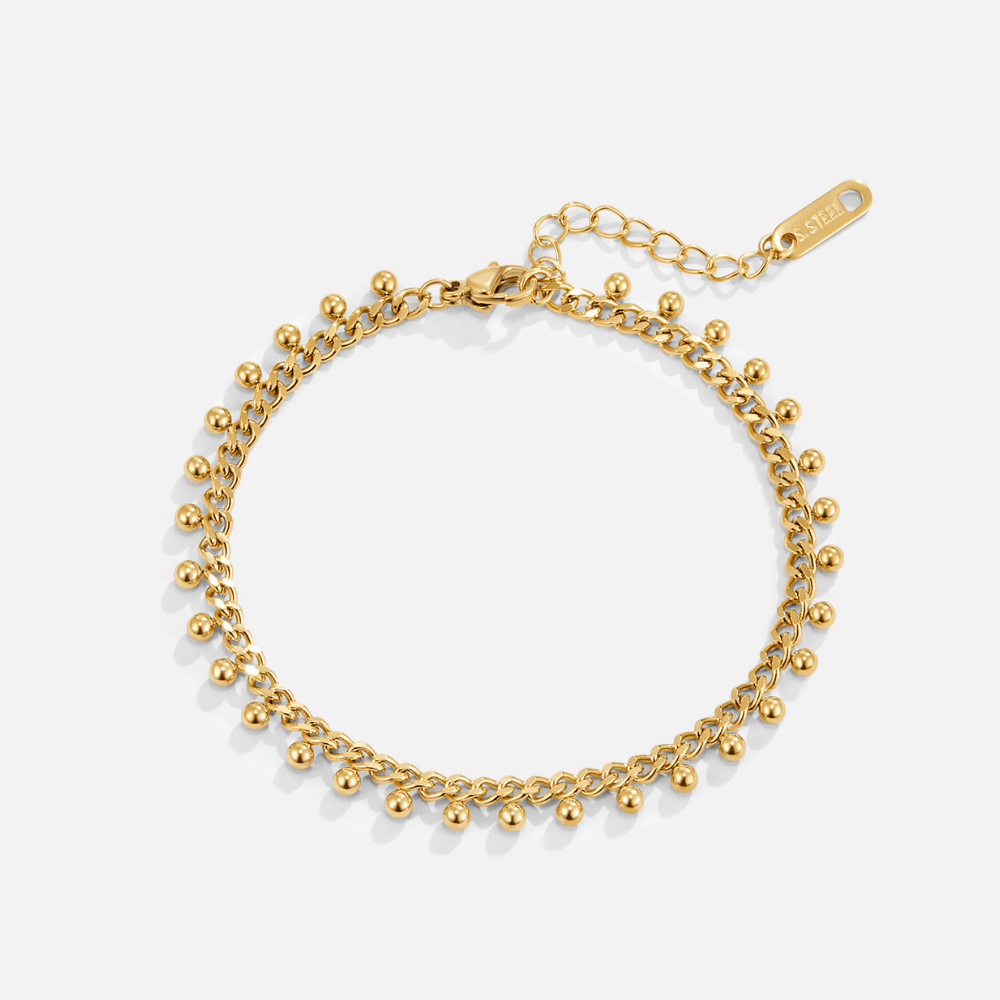 Brie Cuban Chain Droplet Bracelet, flat lay of gold chain bracelet with dangling gold beads on