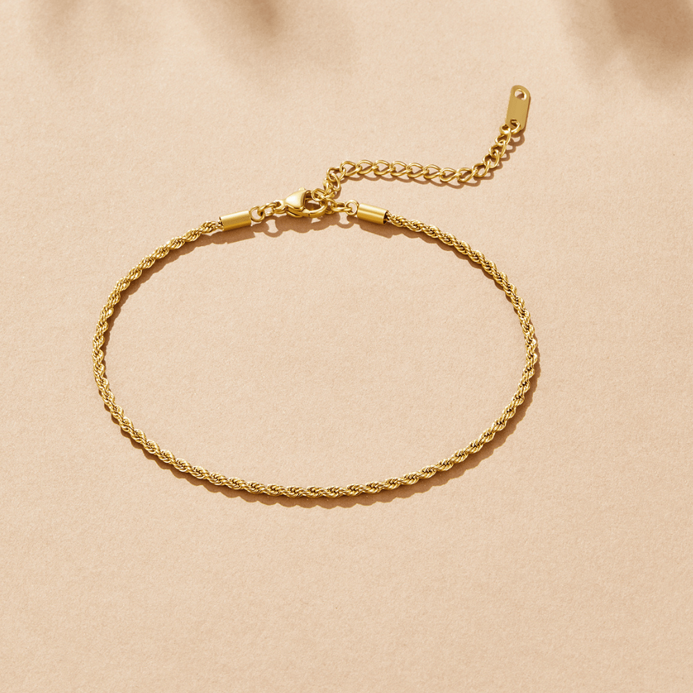 Calla Gold Twisted Chain Anklet, laid flat on beige surface, gold twisted rope chain with