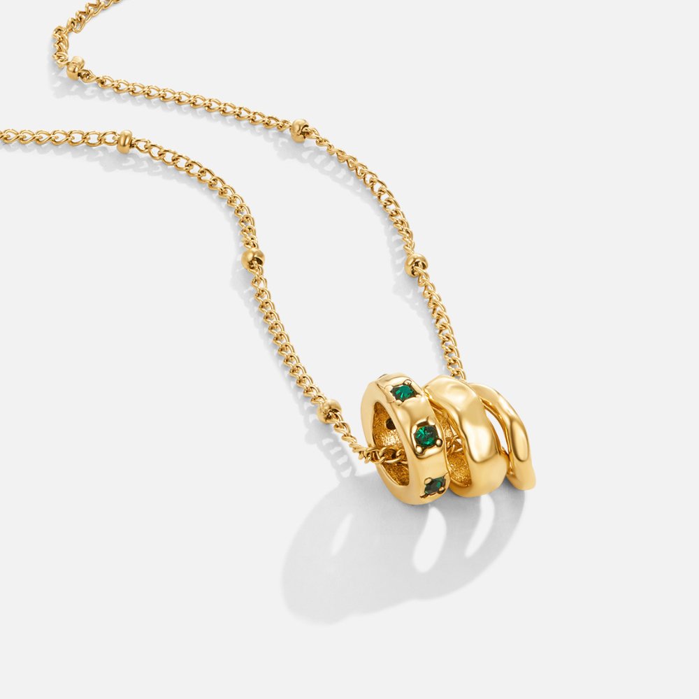 Camilla Pendant Necklace, gold chain with three stacked rings, green stones on one, on white