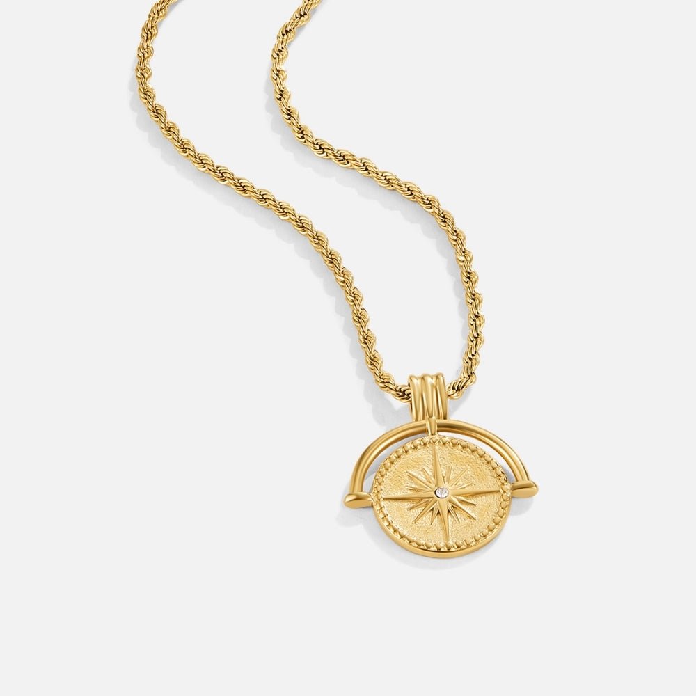 Celestial Gold Coin Necklace, laid flat on white, twisted gold chain with star-compass pendant