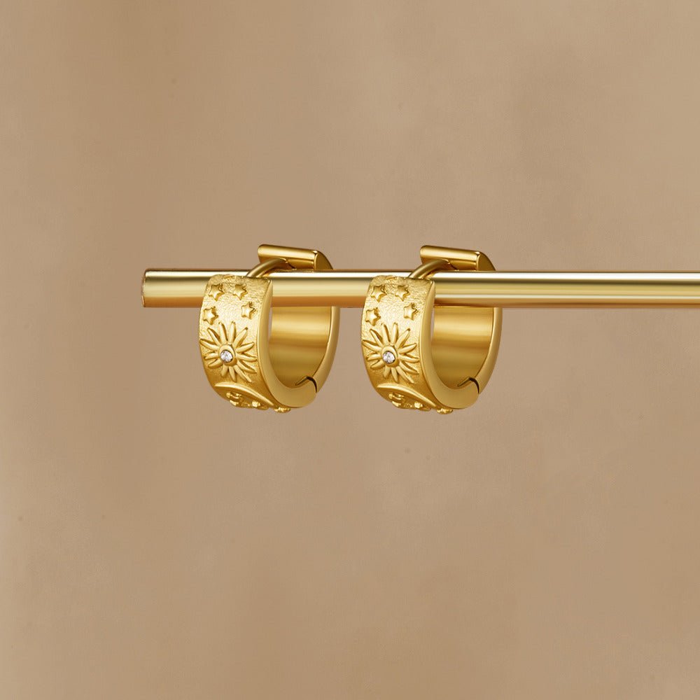 Celestial Gold Hoop Earrings, pair of gold hoops hung on a gold rod against beige, sun and