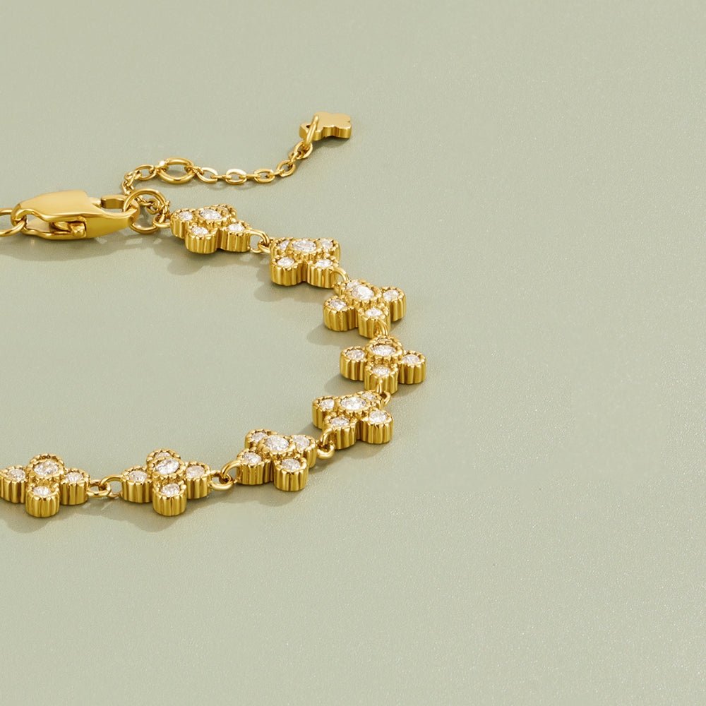 Crystal Blossom Clustered Bracelet, gold bracelet laid flat on sage green, clover links set