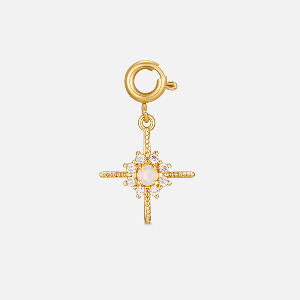 Crystal North Star Charm, gold star charm with a central pale opal and white stones, on a white background