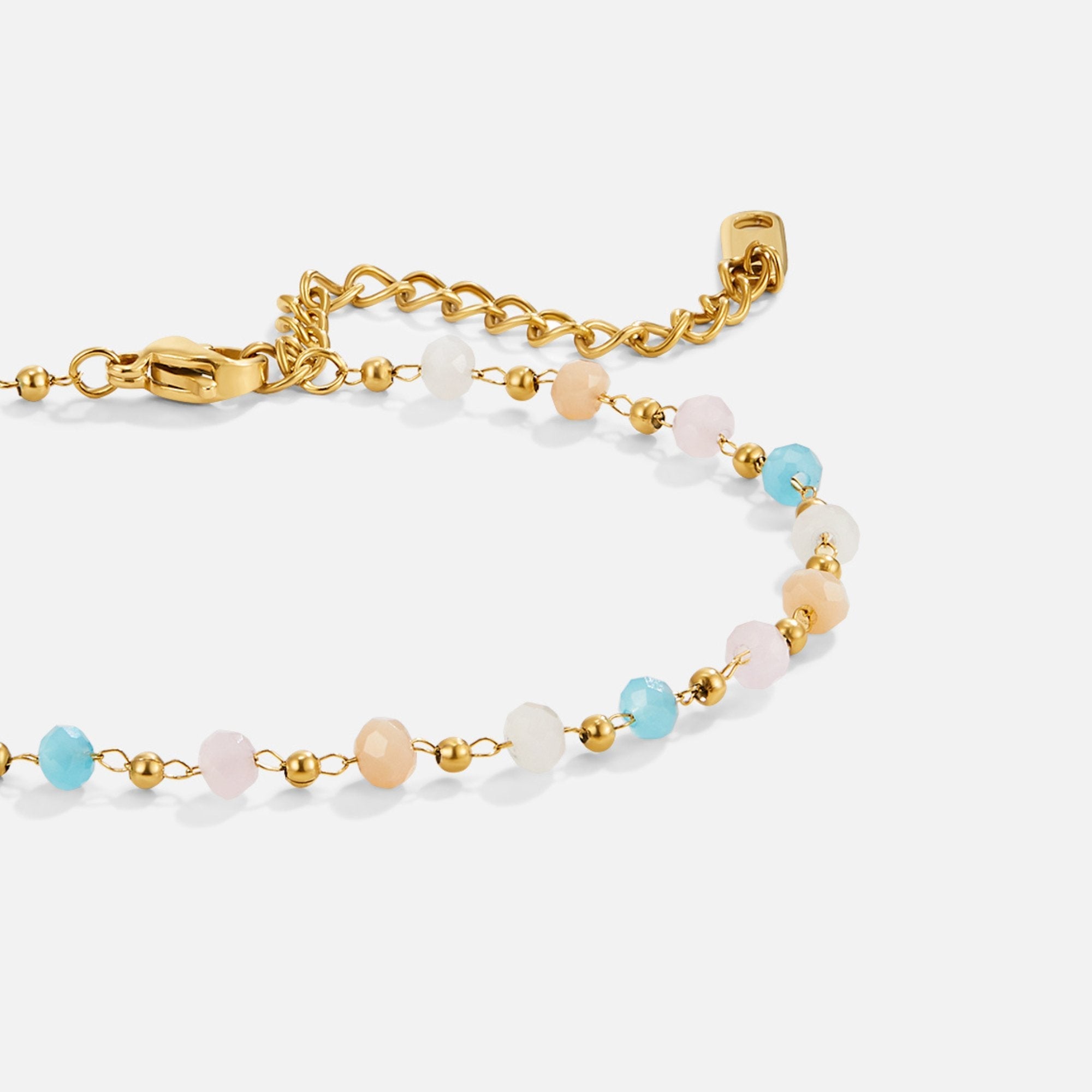 Dalia Beadstone Bracelet, close-up of a gold bracelet with pastel beads, lying on white