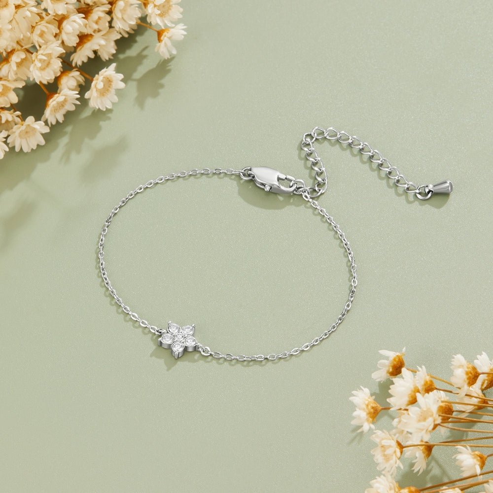 Elara Crystal Bloom Silver Bracelet, laid flat on sage green with dried flowers, clasp open