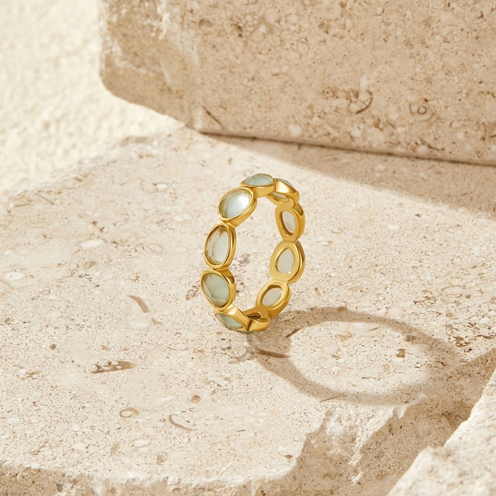 Elise Moonstone Ring, standing upright on a stone ledge with pale teardrop stones