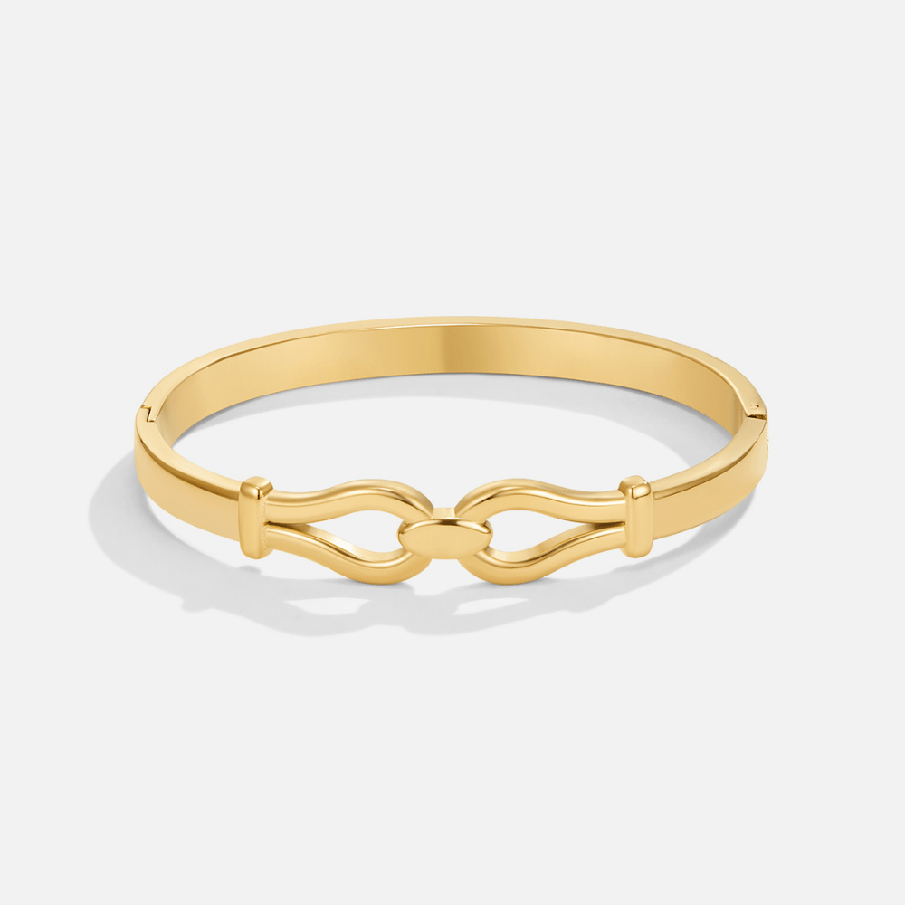 Felicity Gold Bangle, gold hinged bangle lying flat on white, with interlocking loop clasp detail