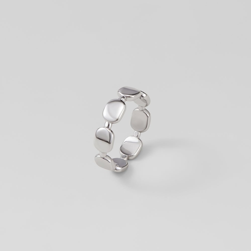 Florence Silver Band Ring, standing upright on grey backdrop, polished silver pebble links