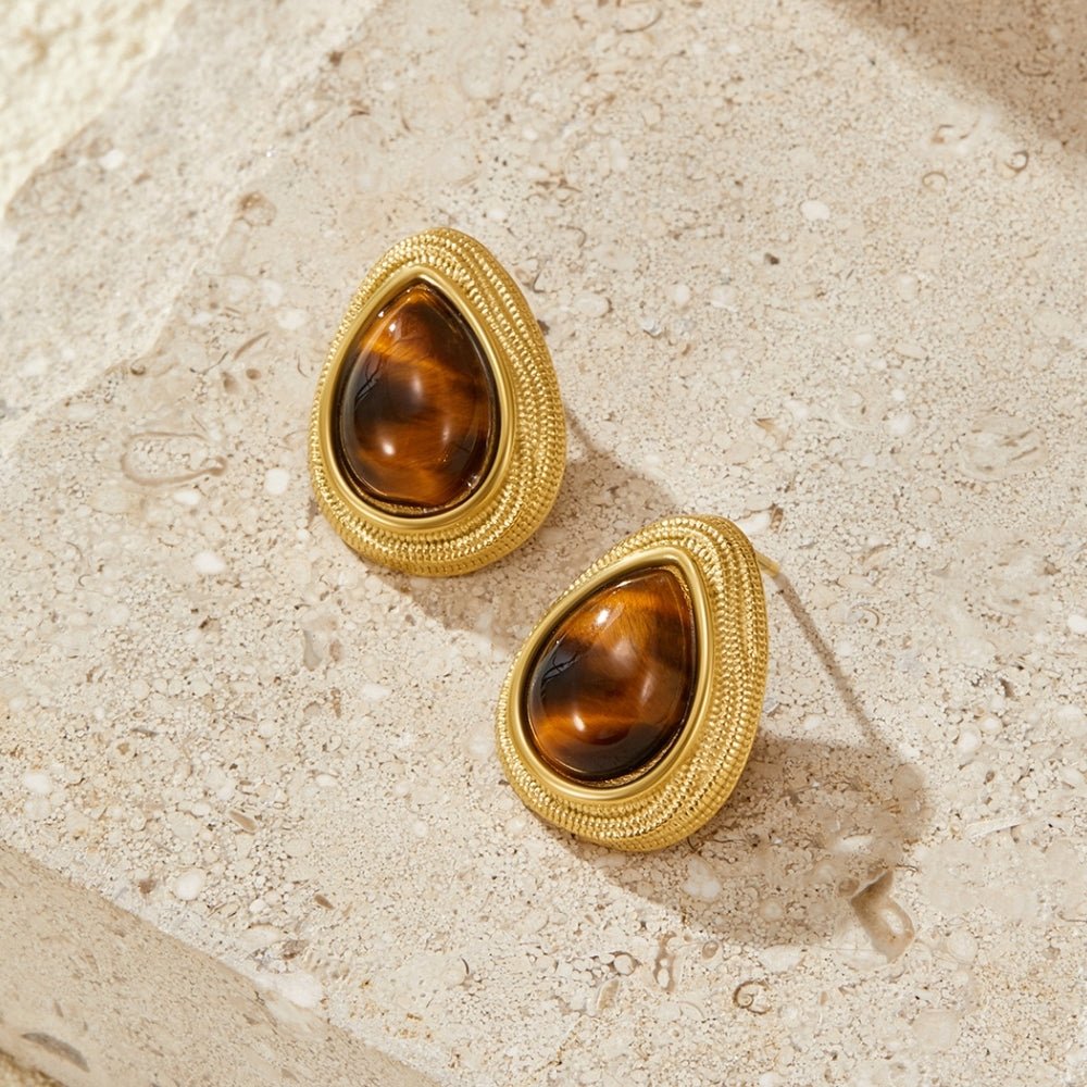 Gold Tiger Eye Teardrop Earrings, pair of earrings lying flat on pale stone, one above the other