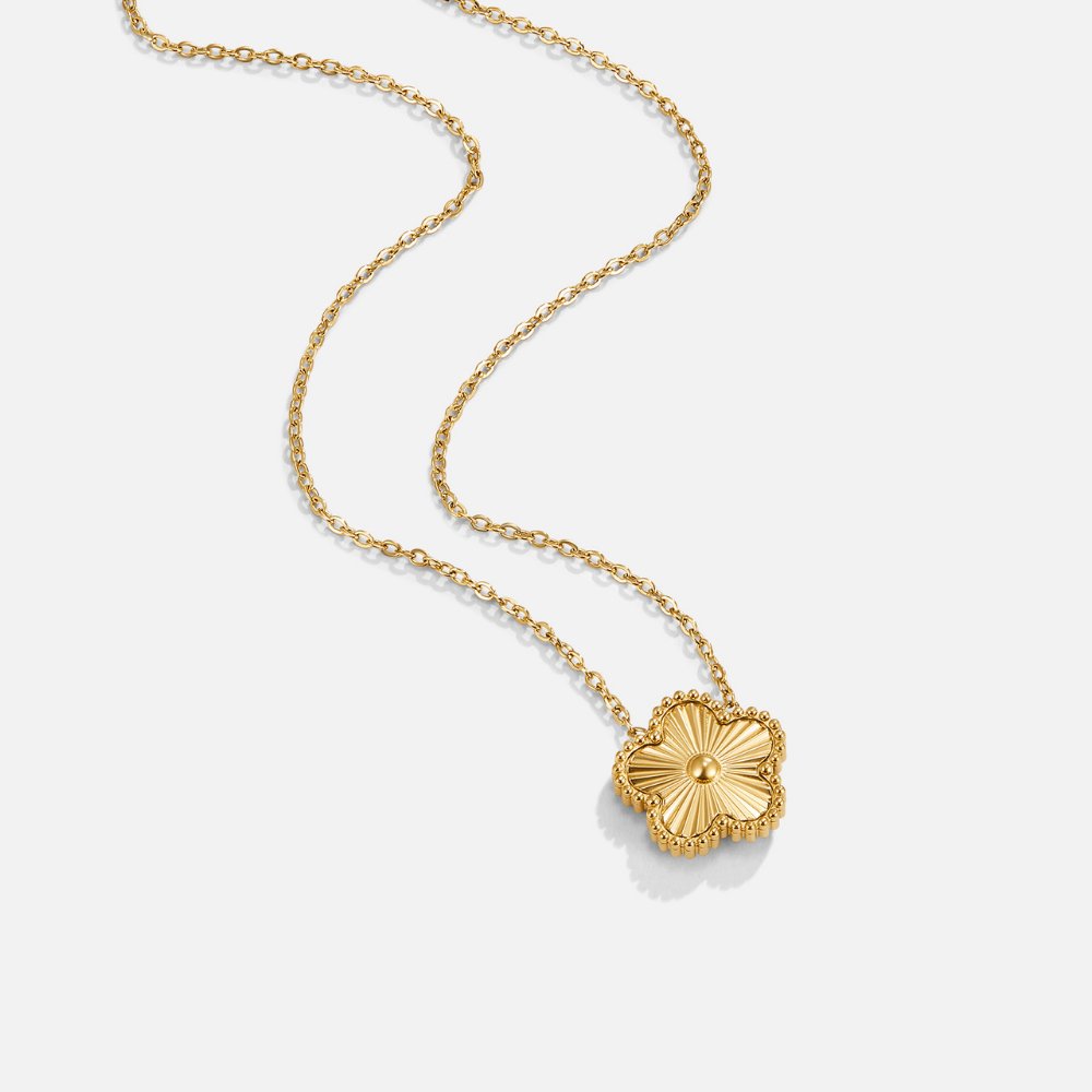 Golden Clover Necklace, gold chain necklace laid flat with a clover pendant, ridged centre