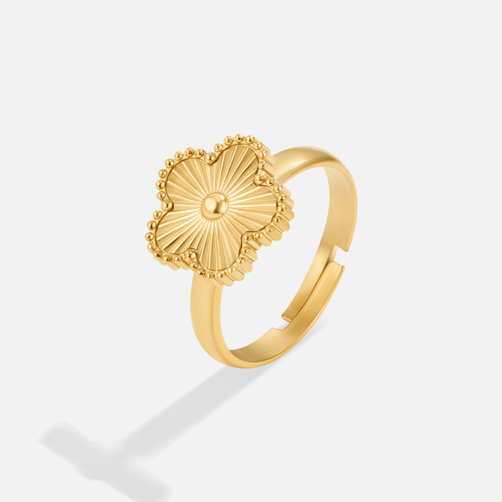 Golden Clover Ring, gold ring with a clover-shaped face and radiating lines, on a white background
