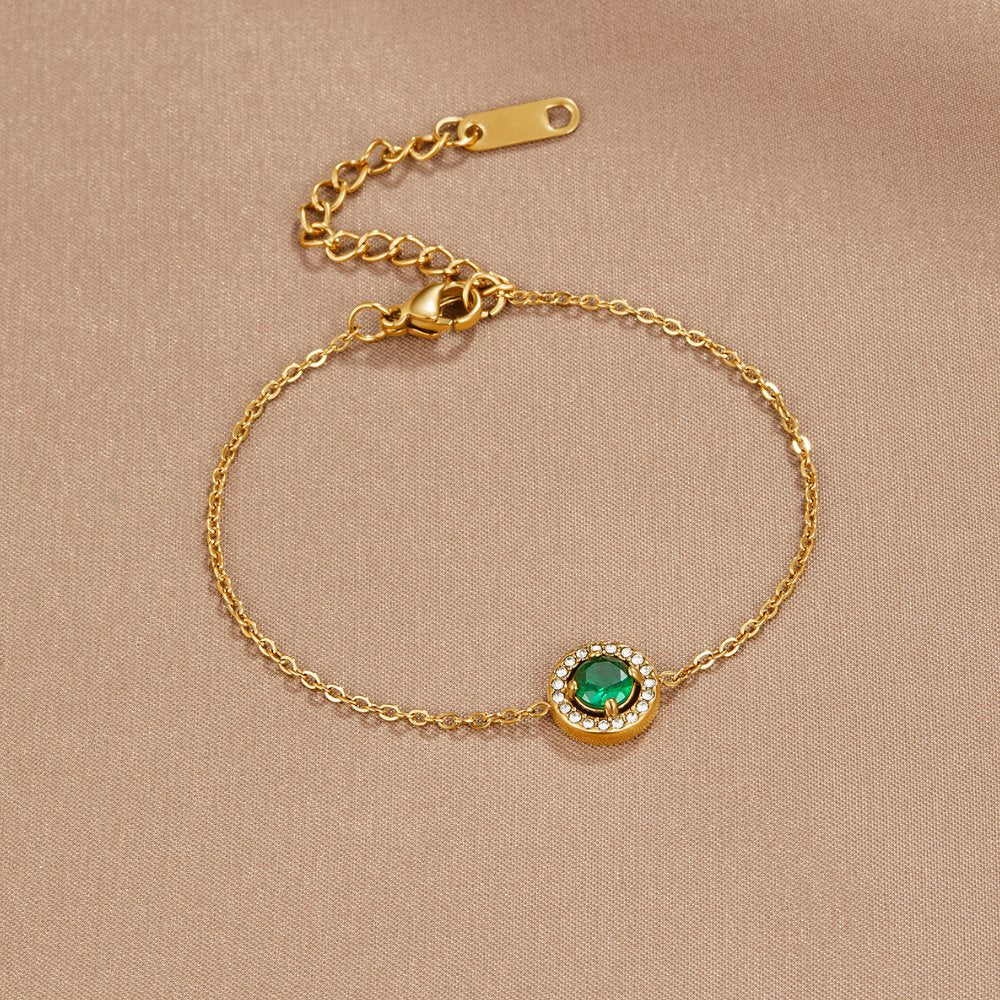 Green Emerald Crystal Bracelet, laid flat on beige satin, green stone with diamond-set halo