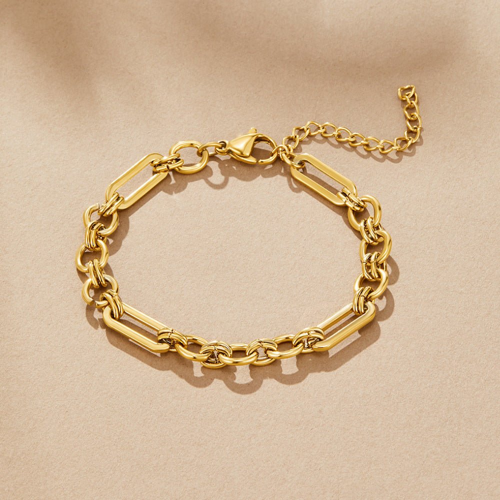 Iris Chunky Gold Bracelet, laid flat on beige fabric, gold chain with lobster clasp and