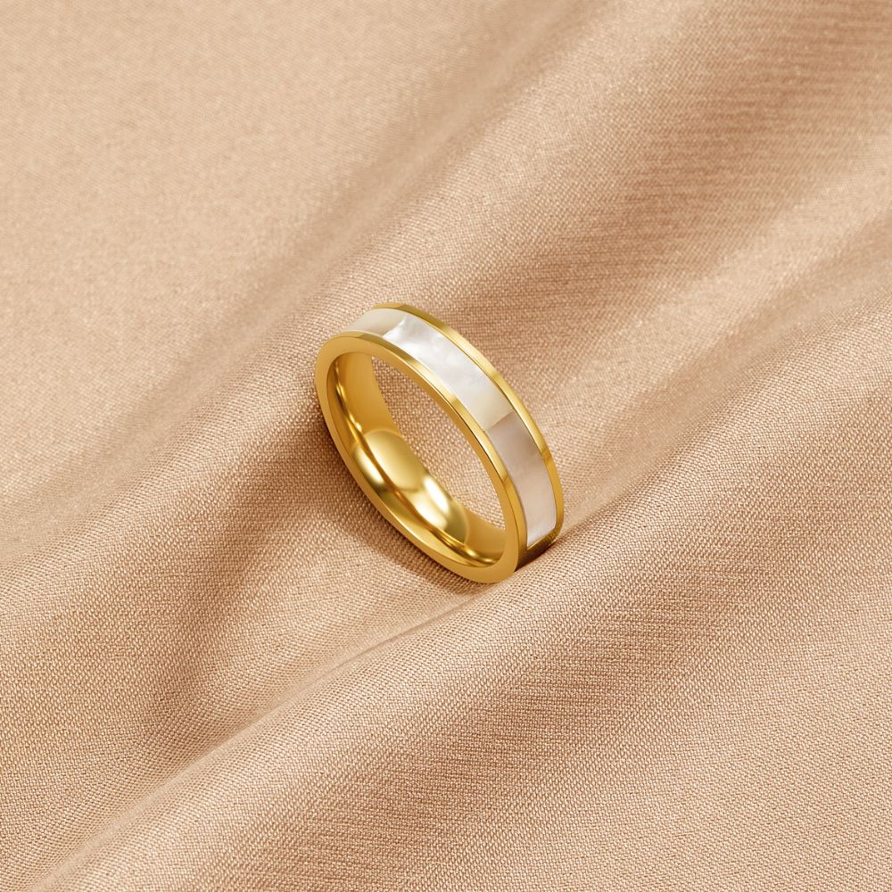 Ivory Pearl Gold Ring, ring lying on draped beige satin, gold band with white inlay