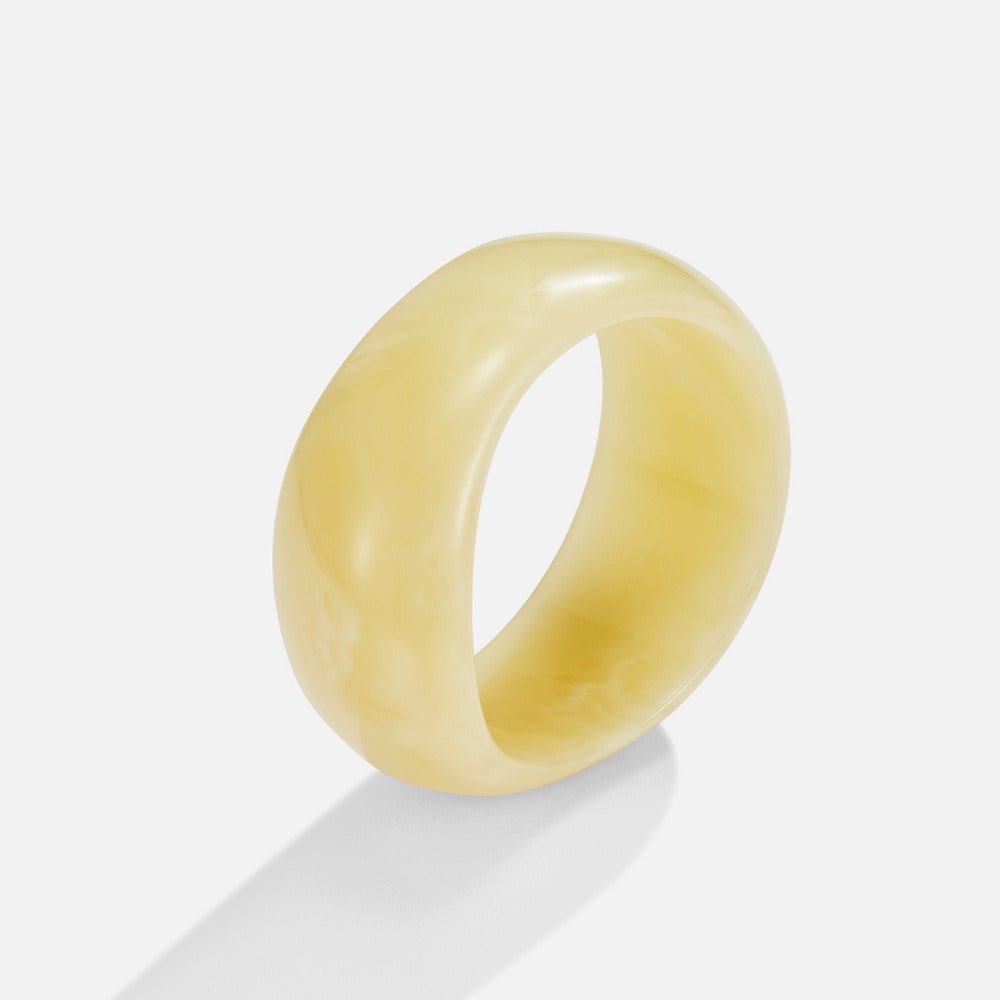 Ivory Swirl Bangle, wide pale yellow resin band standing upright, marbled cream swirls
