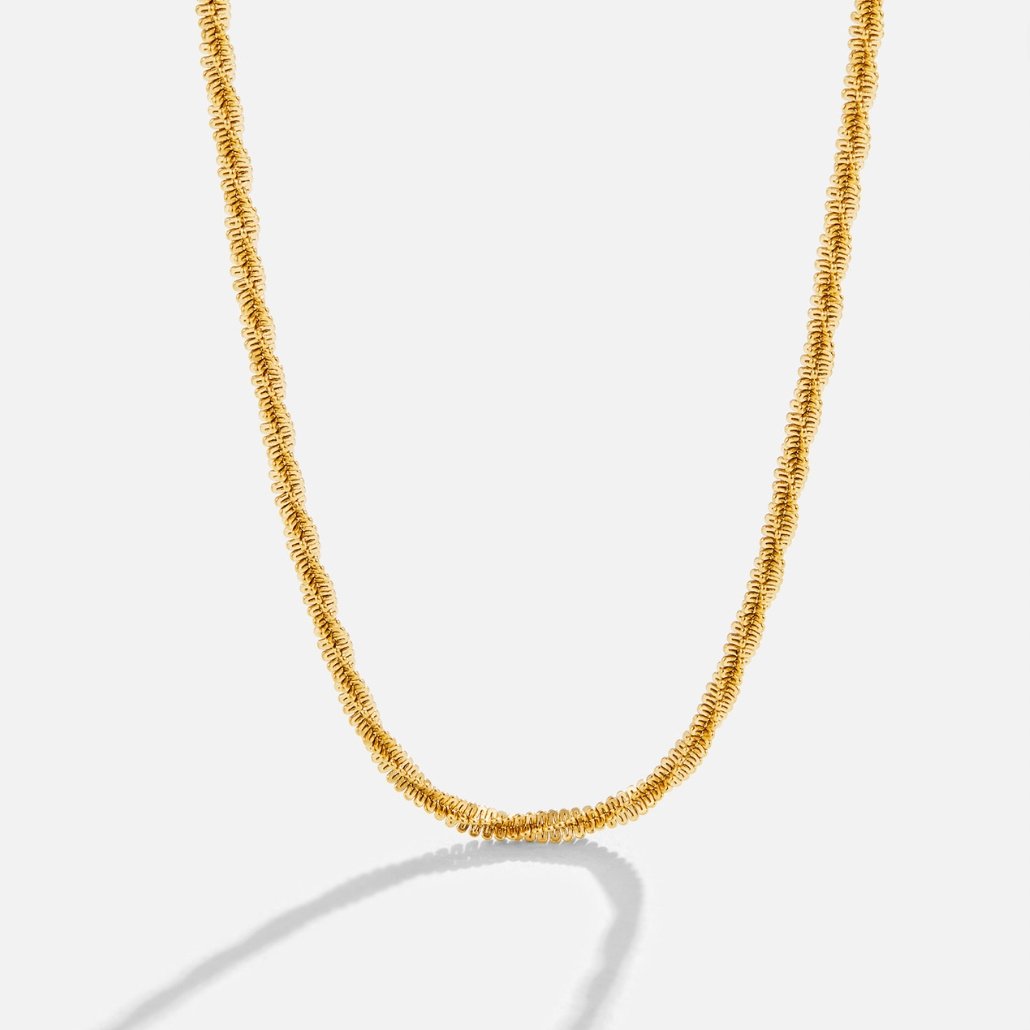 Kai 18K Gold Necklace, gold necklace draped against a plain white background, textured coil links