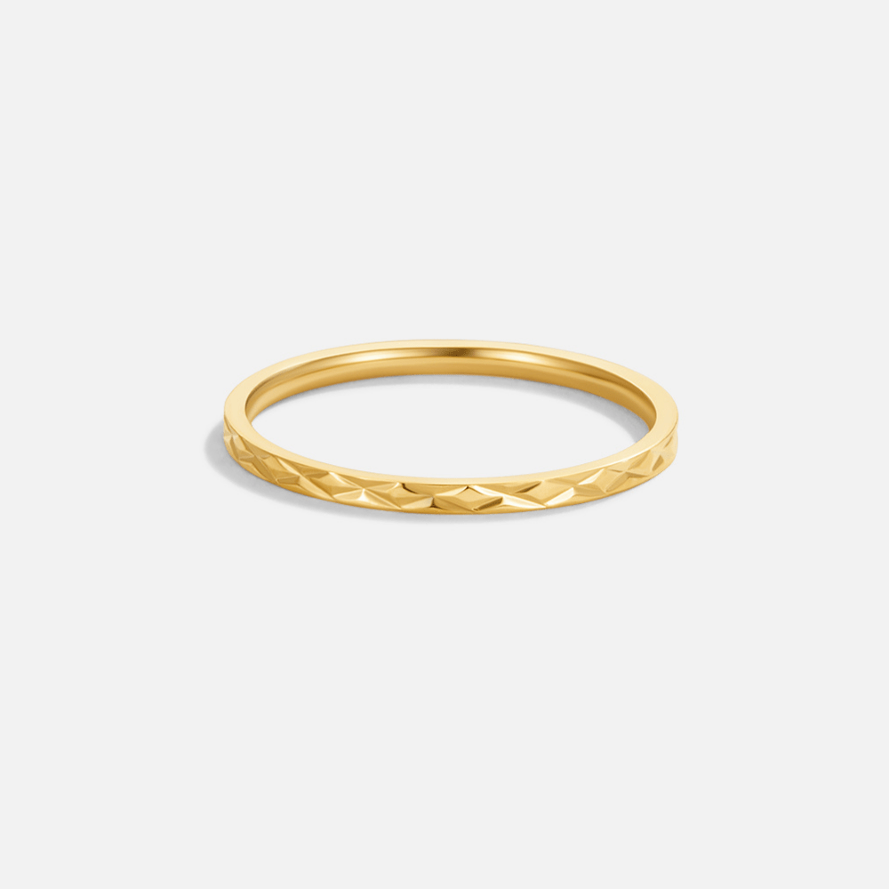 Kanata Gold Band Ring, ring on a plain light background, faceted pattern on the lower band