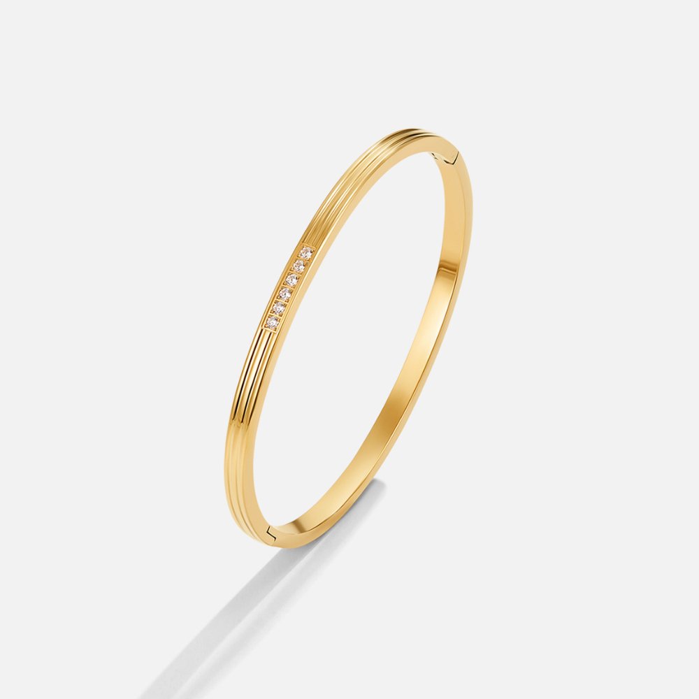 Kim Crystal bangle, gold bangle on a light grey background, with a row of small crystals
