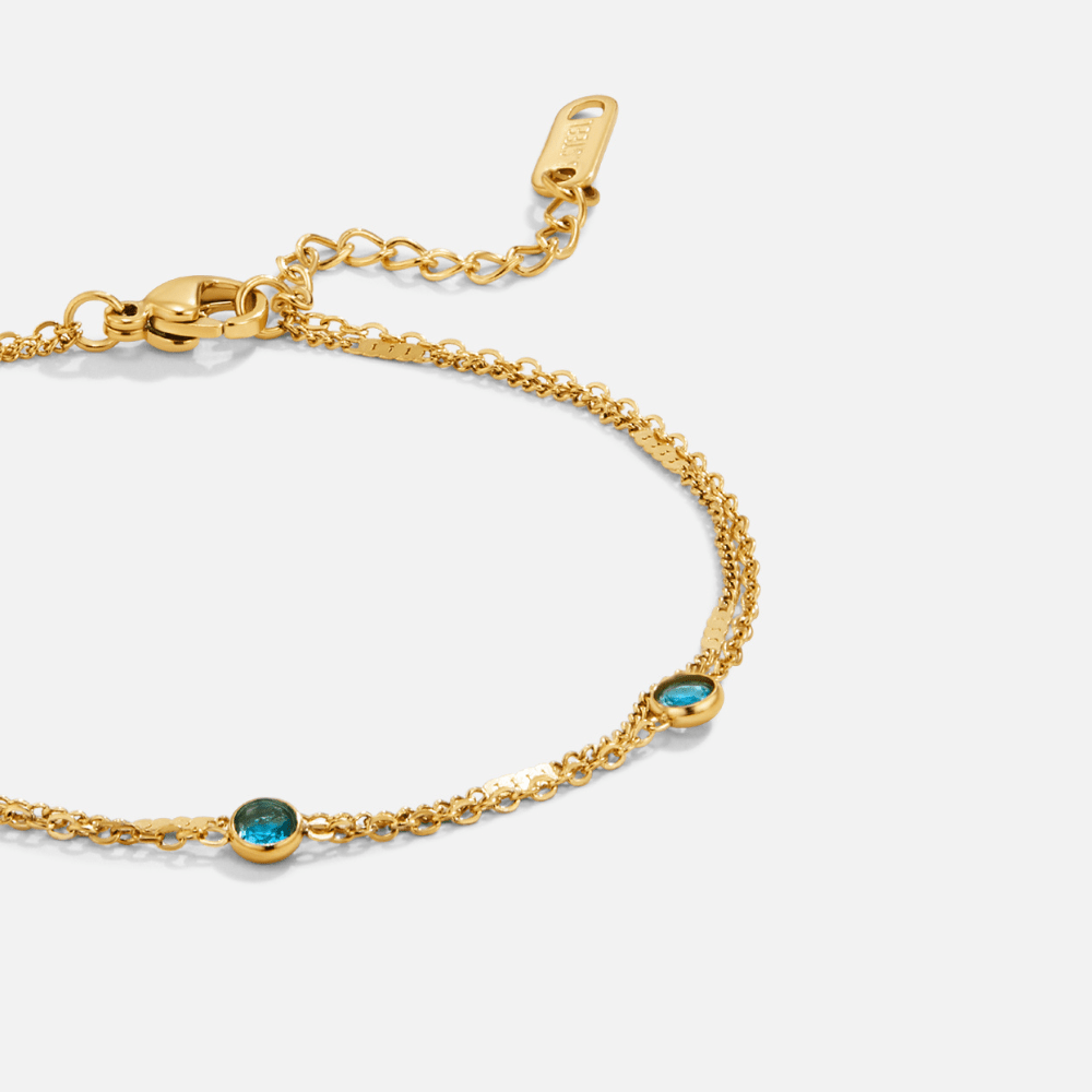 Layered Blue Athena Crystal Bracelet, close-up of double gold chain with two blue round stones