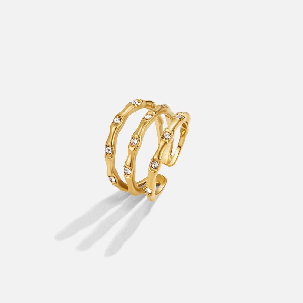 Layered Golden Bamboo Ring, three gold bands stacked open-ended, set with small clear stones on white