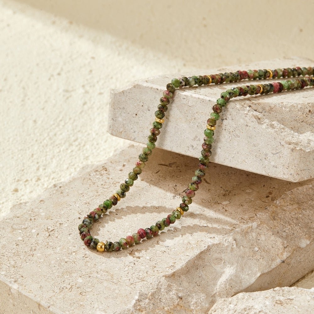 Lush Green Bead Necklace, draped over pale stone with green and pink beads and gold spacers