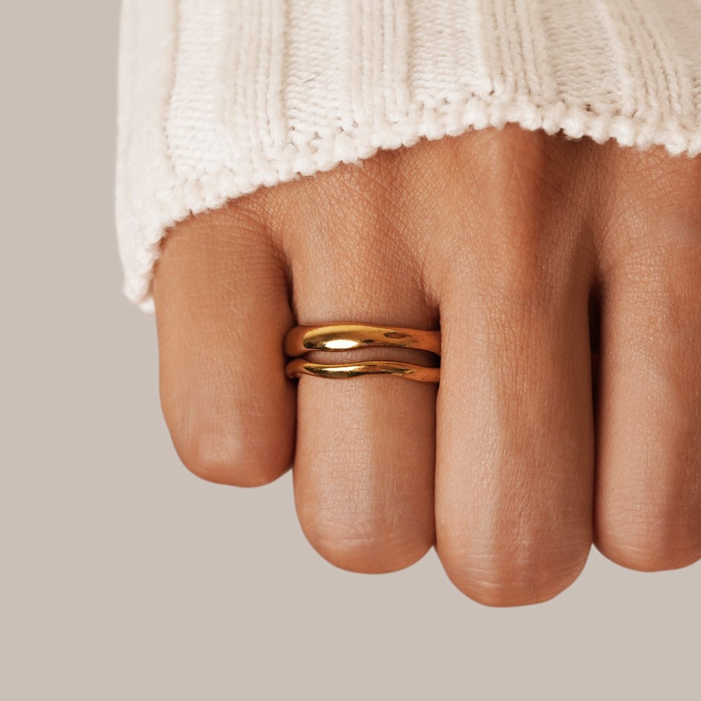 Madison Wave Ring Set, worn on a hand with a white knit sleeve, two stacked gold bands