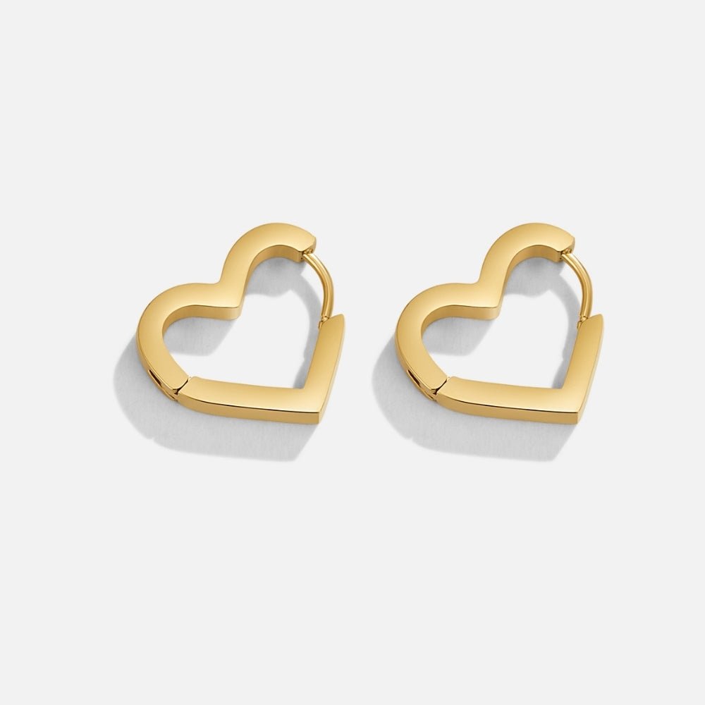 Mary Heart Gold Hoop Earrings, pair of polished gold heart-shaped hoop earrings on white