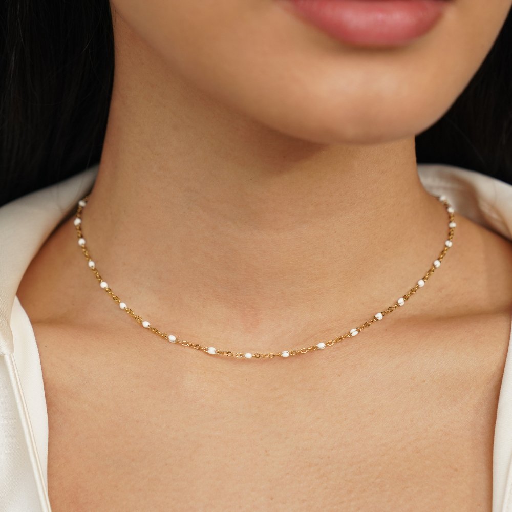 Mila White Bead Necklace, worn at the neck with a white top, gold chain with white beads
