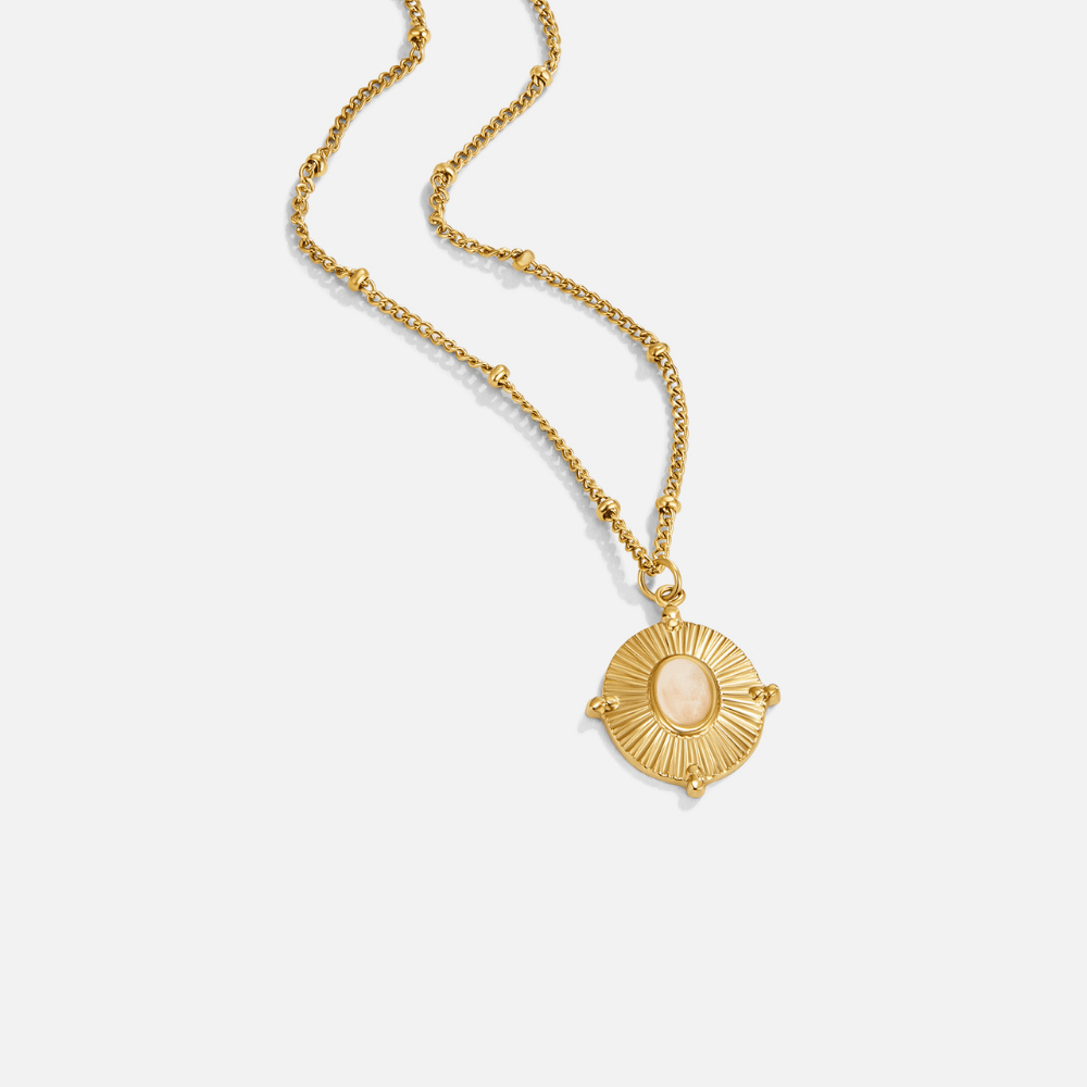 Monique Vintage Stone Necklace, flat lay of a gold necklace with a round pendant and pale stone