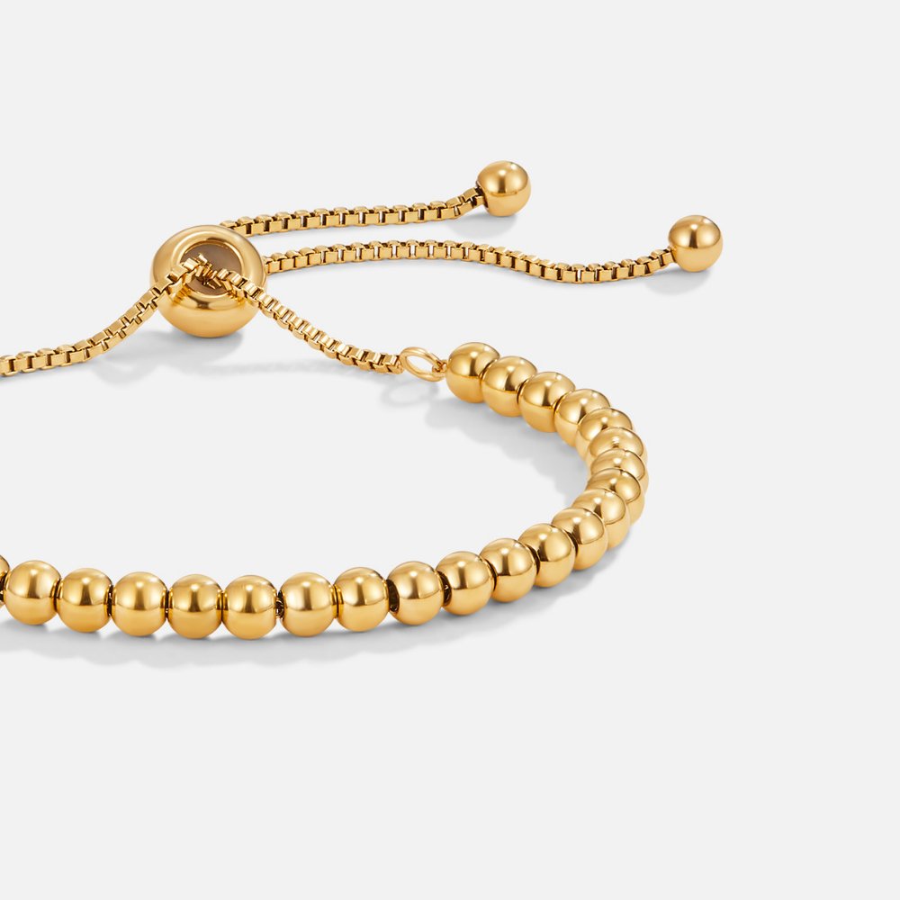 Niloya Beaded Gold Bracelet, close-up of gold beaded bracelet with sliding bolo adjuster on white
