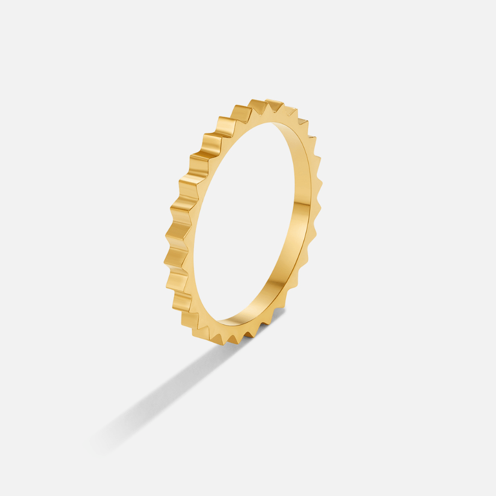 Nora Gold Ring, standing upright on white, angled view of a gold ring with notched edge