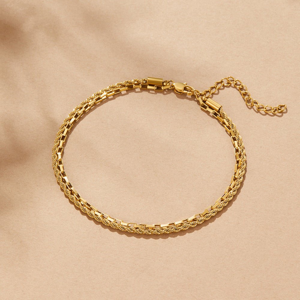 Nora Layered Box Chain Anklet, flat lay of gold chain anklet with lobster clasp and extender chain on beige fabric