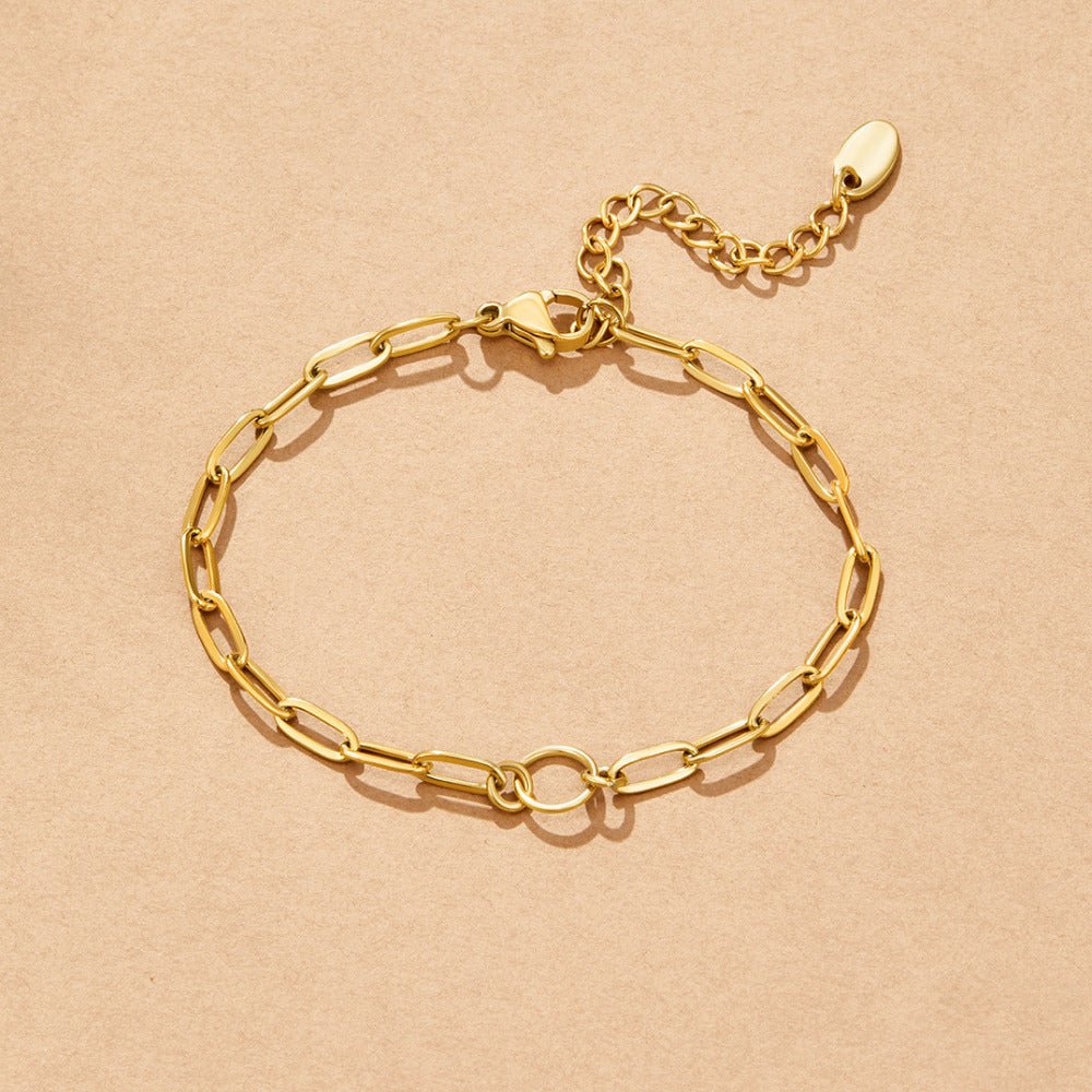 Pia Chain Link Charm Bracelet, laid flat on beige paper, gold paperclip chain with clasp