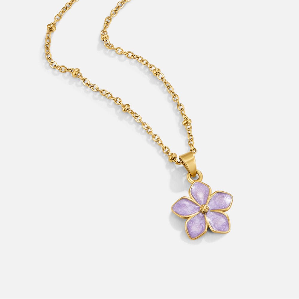 Purple Sakura Bloom Gold Necklace, gold chain necklace laid flat with a five-petal lilac flower pendant