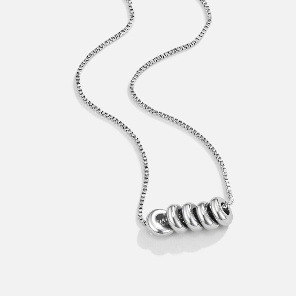 'Rings of Hapiness' Silver Necklace, laid flat on white, silver box chain with five linked rings
