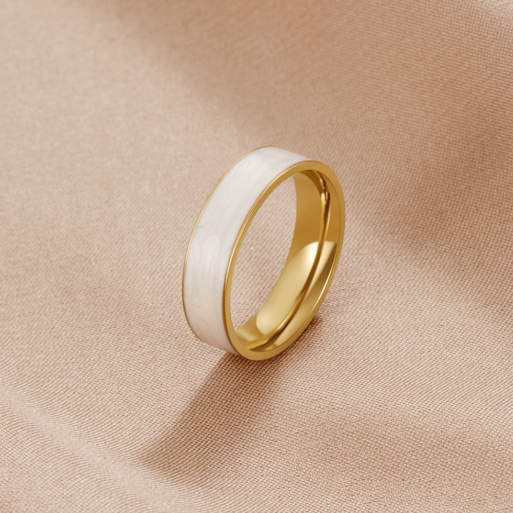 Sahara White Band Ring, standing upright on beige fabric, white enamel band with gold edges